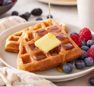 Pinterest graphic of a plate with Belgian waffles with butter and fruit. Syrup poured over top.