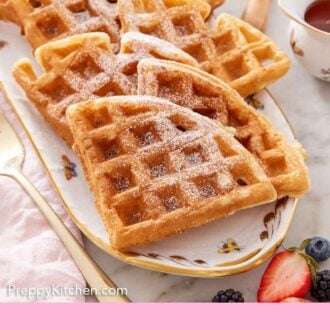 Pinterest graphic of a platter with multiple triangle pieces of Belgian waffles topped with powdered sugar.