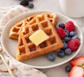 Pinterest graphic of a plate with Belgian waffles wtih butter and berries. Coffee in the background.