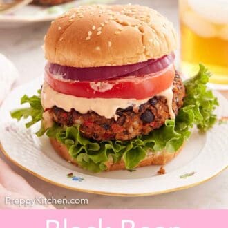 Pinterest graphic of a black bean burger with lettuce, sauce, tomato, and red onions.