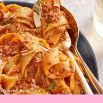 Pinterest graphic of a close up of bolognese on a fork in a plate.