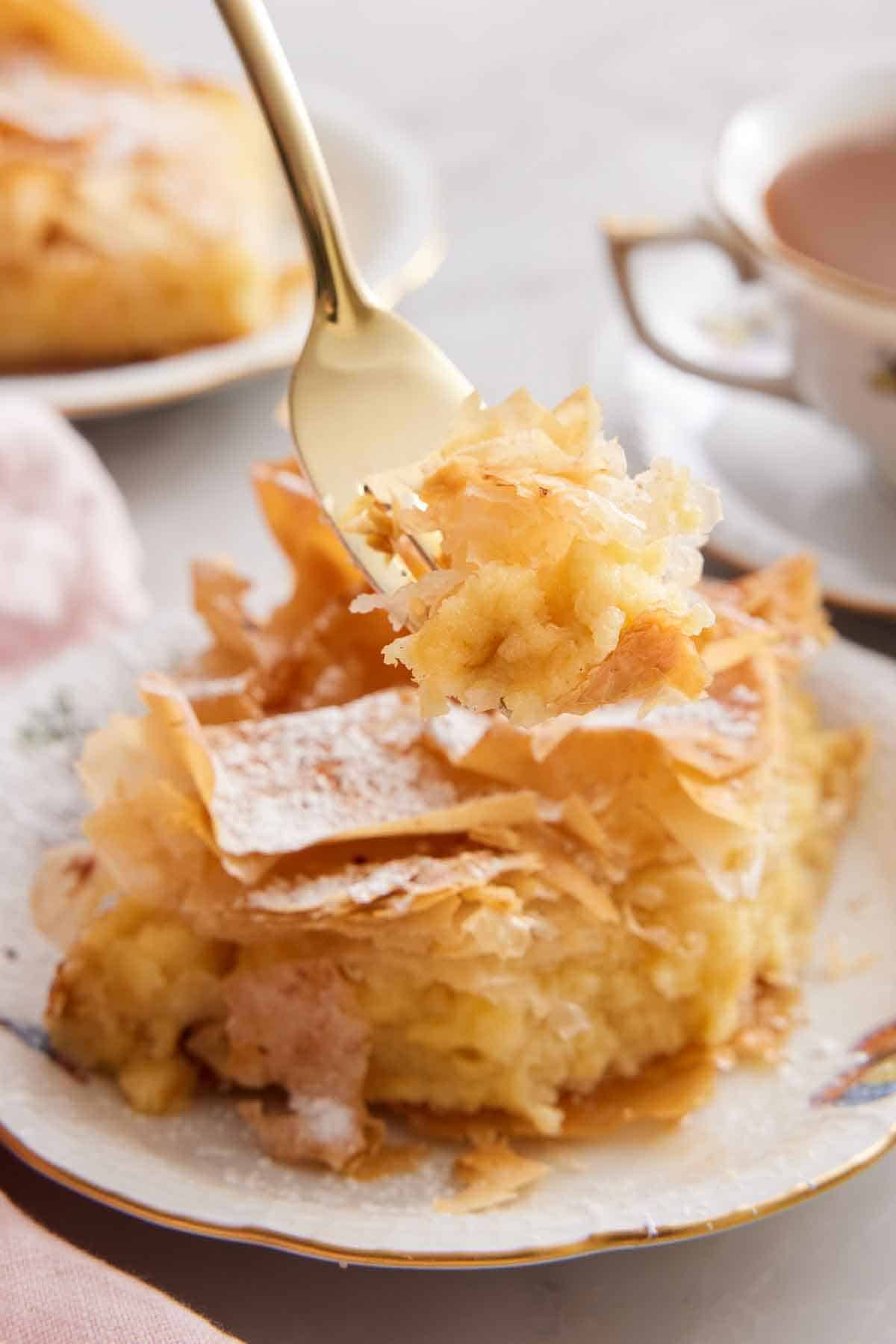 A forkful of Bougatsa lifted from a plated serving.