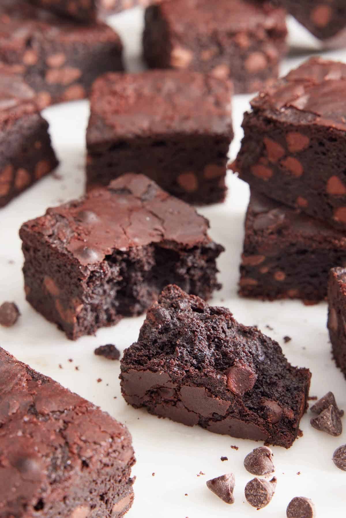 Multiple brownies on a flat surface with one in the middle torn open.