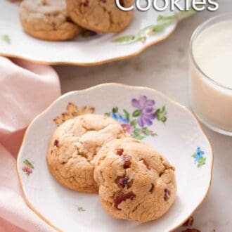 Pinterest graphic of two butter pecan cookies on a plate with a glass of milk and platter in the background.