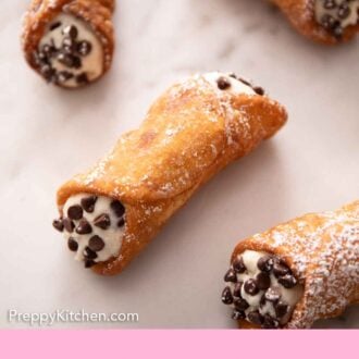Pinterest graphic of a marble surface with multiple cannoli.