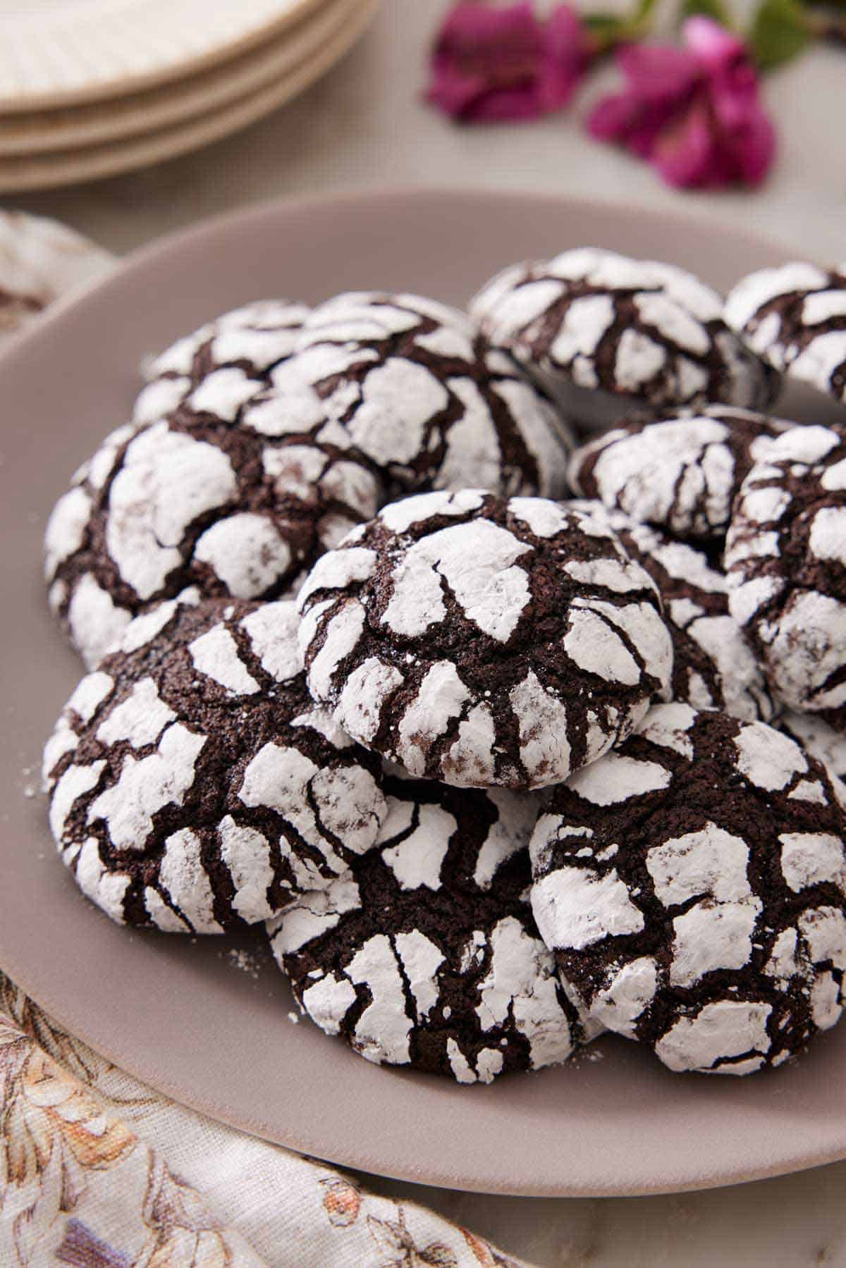 A large plate with a pile of chocolate crinkle cookies.