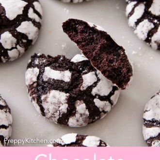 Pinterest graphic of chocolate crinkle cookies scattered on a marble surface with the one in the middle broke in half, showing the interior.