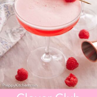 Pinterest graphic of Clover Club Cocktail in a coupe glass with three raspberries as a garnish with more raspberries scattered on the counter.