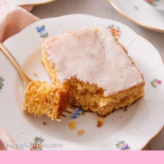Pinterest graphic of a plate with a slice of honey bun cake with the corner bite on a fork.