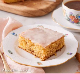 Pinterest graphic of a slice of honey bun cake with a cup of coffee and the rest of the cake in the background.