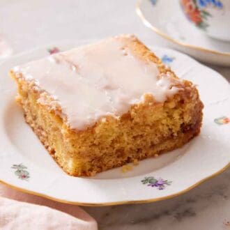 A square slice of honey bun cake with a fork beside it.