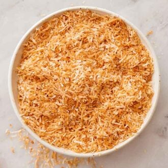 Overhead view of toasted coconut in a bowl.