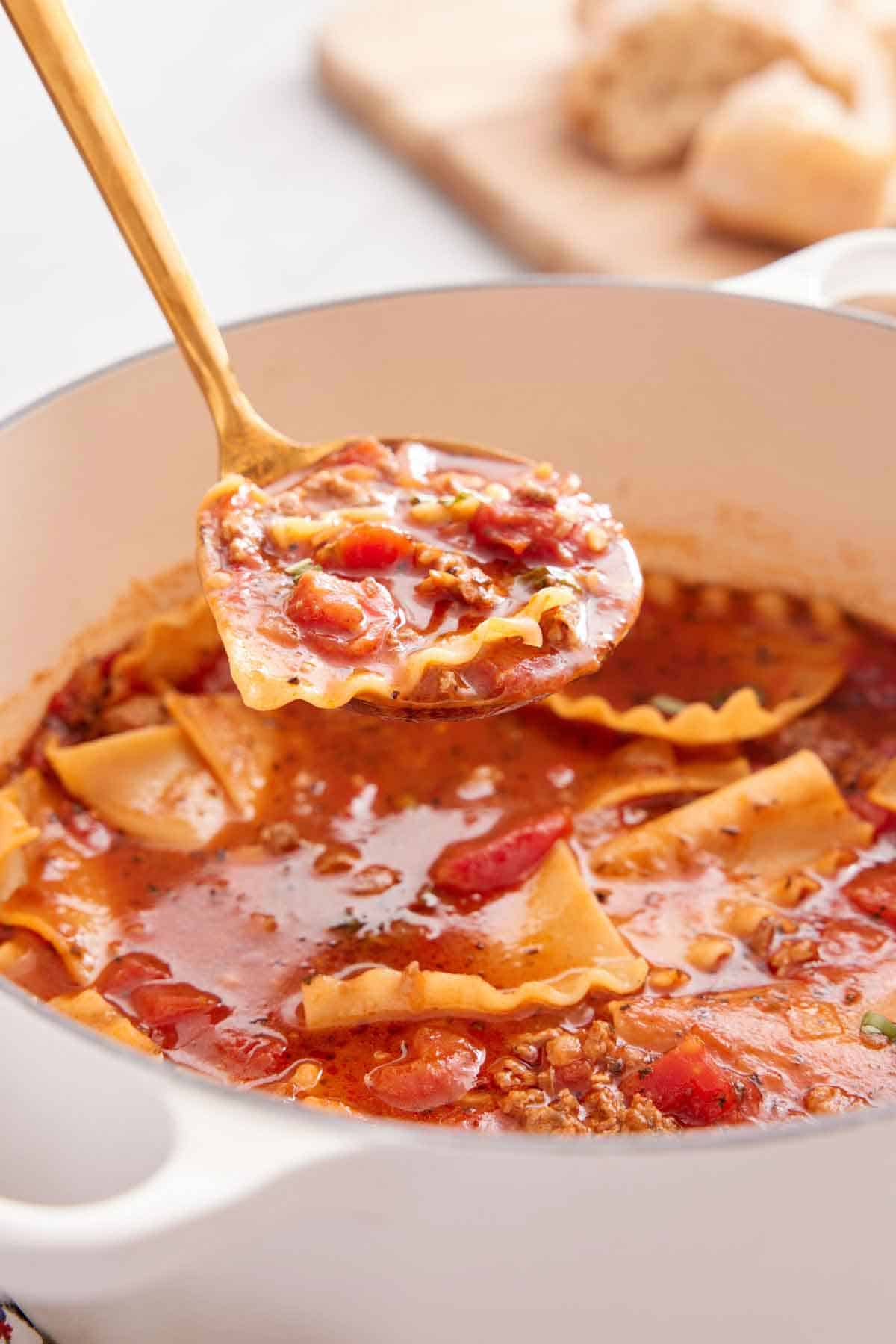 A ladle of lasagna soup scooped out of a pot.