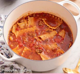 Pinterest graphic of a slightly overhead view of a bowl of lasagna soup with torn bread in the background.