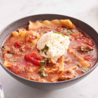 A bowl of lasagna soup with a dollop of ricotta in the middle.