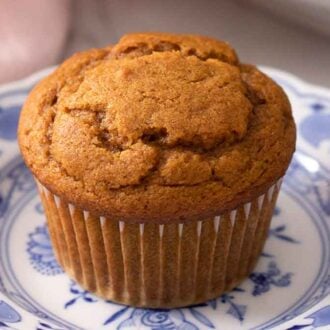 Close up view of a pumpkin muffin on a plate.