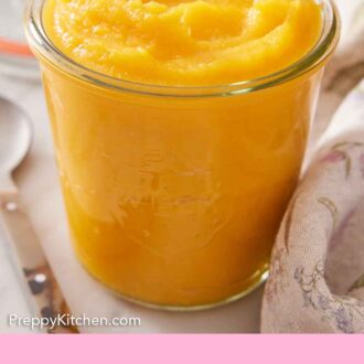 Pinterest graphic of a glass jar of pumpkin puree with a spoon on the side and a pumpkin in the background.