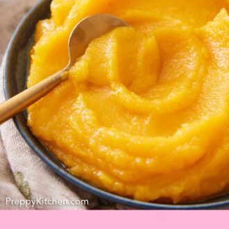 Pinterest graphic of a bowl of pumpkin puree with a spoon inside.