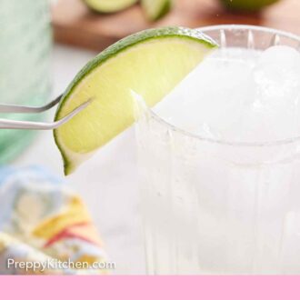 Pinterest graphic of a lime being placed on the rim of a glass of ranch water with tweezers.