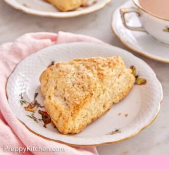 Pinterest graphic of a plate with a scone in it with a cup of coffee and second scone in the background.