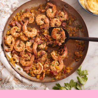 Pinterest graphic of an overhead view of a skillet of cooked shrimp and a bowl of grits off to the side.