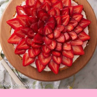 Pinterest graphic of an overhead view of a strawberry tart with a stack of plates and forks to the side.