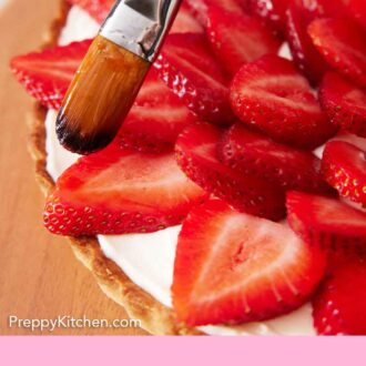 Pinterest graphic of jam being brushed onto sliced strawberries on a strawberry tart.