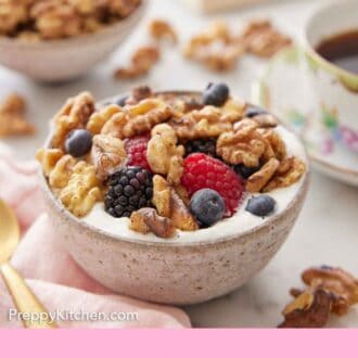 Pinterest graphic of a bowl of yogurt with berries and toasted walnuts.