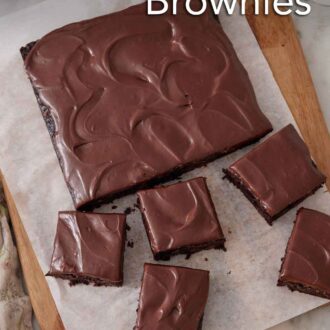 Pinterest graphic of a slab of zucchini brownies on a lined cutting board with five pieces cut.