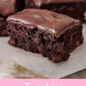 Pinterest graphic of a close up view of a square slice of zucchini brownie, showing the interior and chocolate chips.