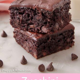 Pinterest graphic of a stack of two zucchini brownies with a glass of milk and chocolate chips on the side.