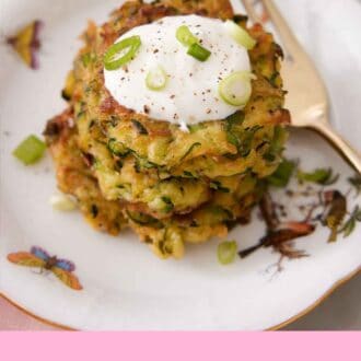 Pinterest graphic of a stack of zucchini fritters with a dollop of sour cream on top, garnished with green onions.
