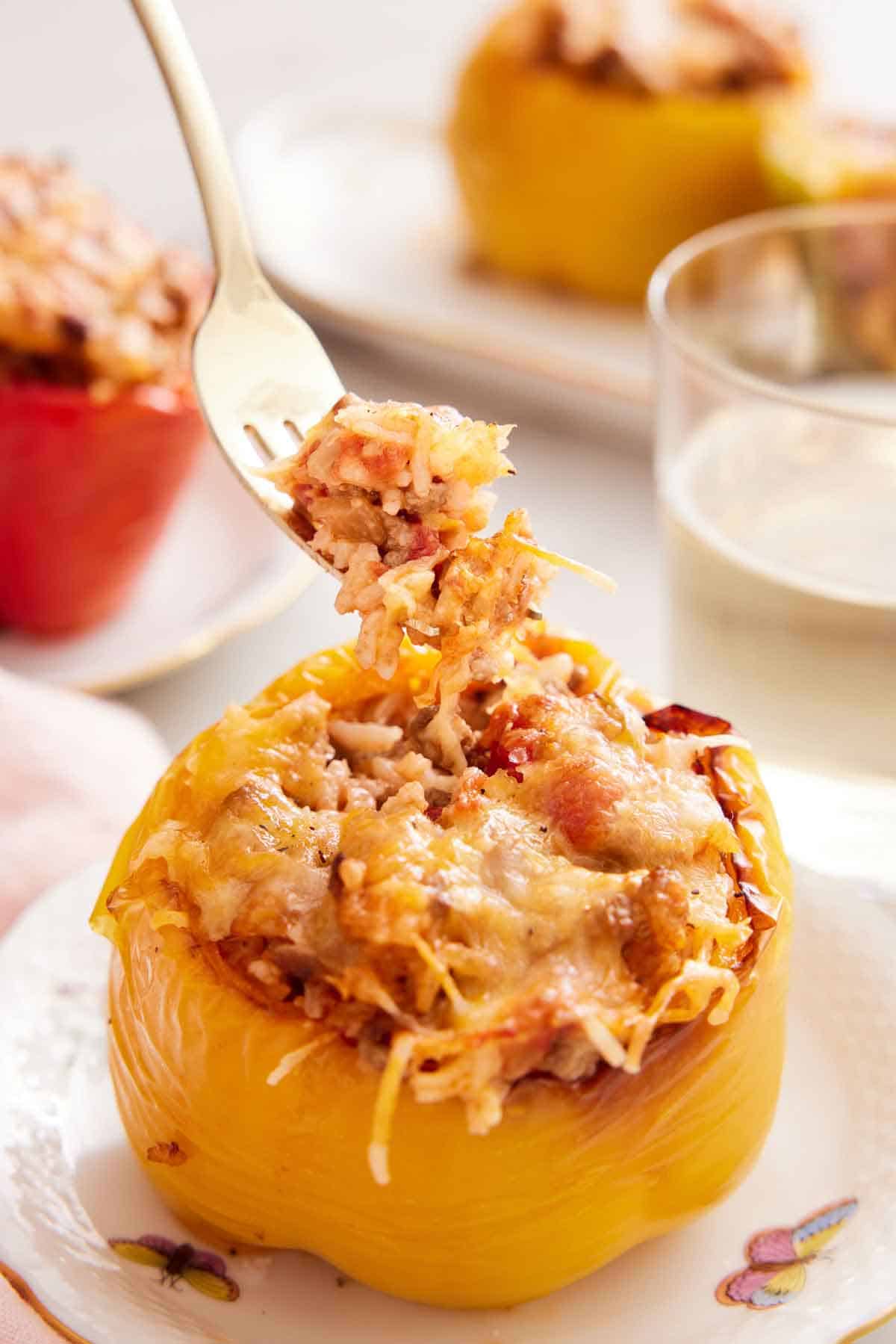 A fork lifting up a bite of rice from the air fryer stuffed peppers.