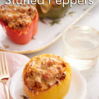 Pinterest graphic of a plate with a serving of air fryer stuffed pepper with a glass of water and additional stuffed peppers in the background.