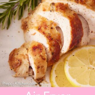 Pinterest graphic of a close up view of sliced turkey breast cooked in the air fryer. Two lemon slices and fresh rosemary beside it.