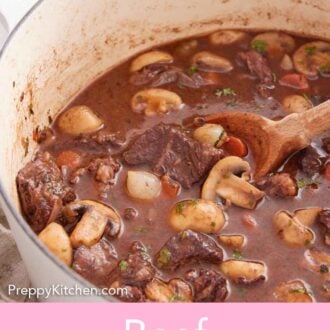 Pinterest graphic of a large white pot of beef bourguignon with a wooden spoon tucked inside.