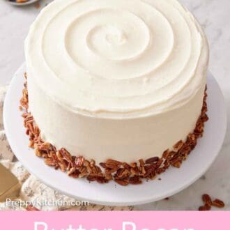 Pinterest graphic of a butter pecan cake on a cake stand. A stack of plates and a bowl of pecans in the background.