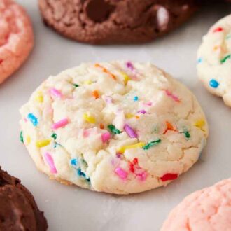 Multiple cake mix cookies on a marble surface in a single layer.
