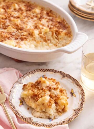 A plate of cauliflower gratin with a baking dish in the background.