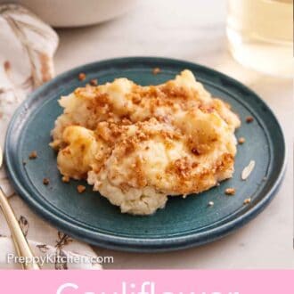Pinterest graphic of plate with a serving of cauliflower gratin with a glass of wine in the background.
