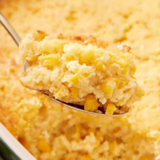 A spoonful of corn casserole lifted from the baking dish.