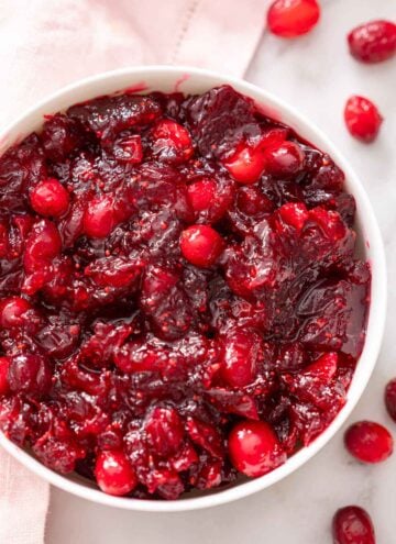 Overhead view of a bowl of cranberry sauce with pieces of whole cranberries.