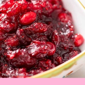 Pinterest graphic of close up view of cranberry sauce in a bowl.