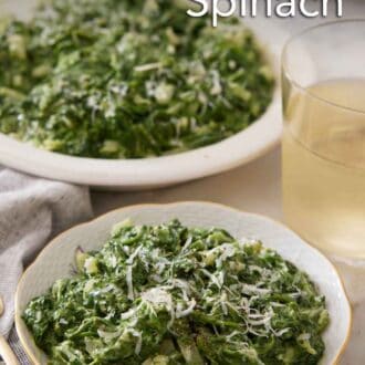 Pinterest graphic of a bowl of creamed spinach with a drink and serving platter of creamed spinach in the background.