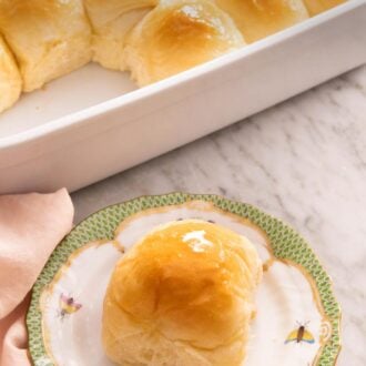 Pinterest graphic of a plate with a dinner roll with a baking dish with more in the back.