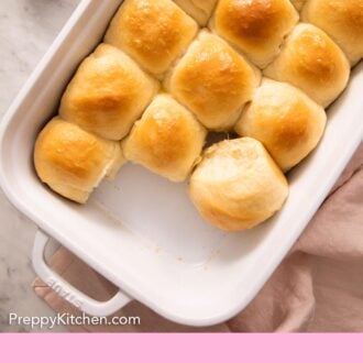 Pinterest graphic of an overhead view of a baking dish with dinner rolls with two removed.
