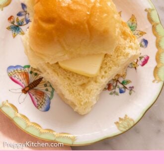 Pinterest graphic of a plate with a dinner roll, sliced, with a piece of butter placed in between.