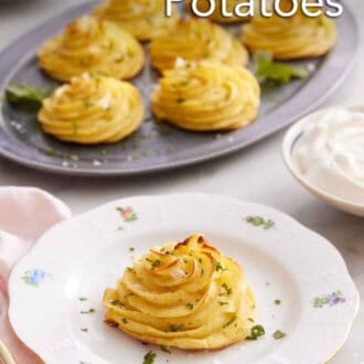 Pinterest graphic of a plate with a serving of duchess potatoes with a platter with more in the background.