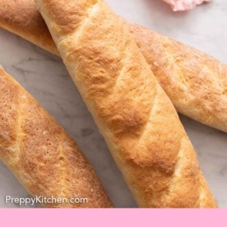Pinterest graphic of three long loaves of French bread on a marble surface.