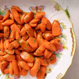 Pinterest graphic of an overhead view of a plate of glazed carrots with chopped parsley garnish.